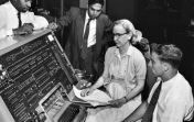 Pioneer computer scientist Grace Hopper sits at the UNIVAC keyboard, c. 1960. CC BY 2.0.